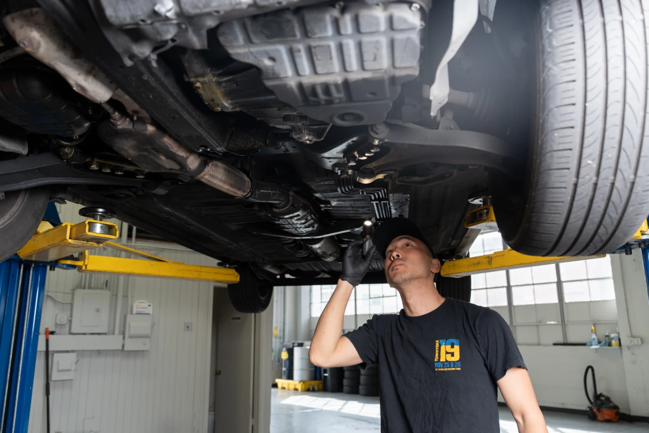 Technician inspecting under vehicle